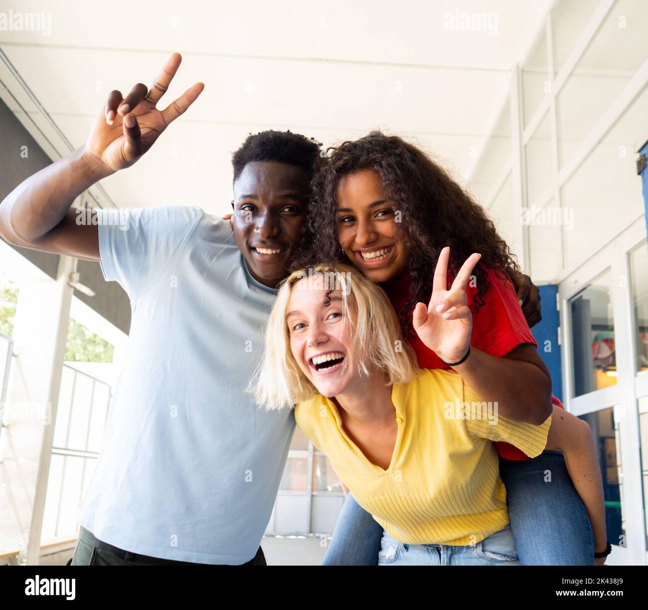 Trois jeunes multiethniques rient et s'amusent sur le campus Banque D'Images