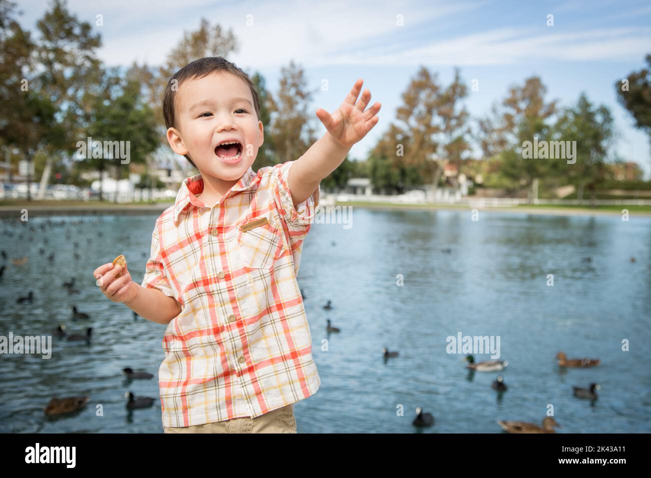 Jeune garçon chinois et caucasien s'amuser au parc et à l'étang de Duck. Banque D'Images
