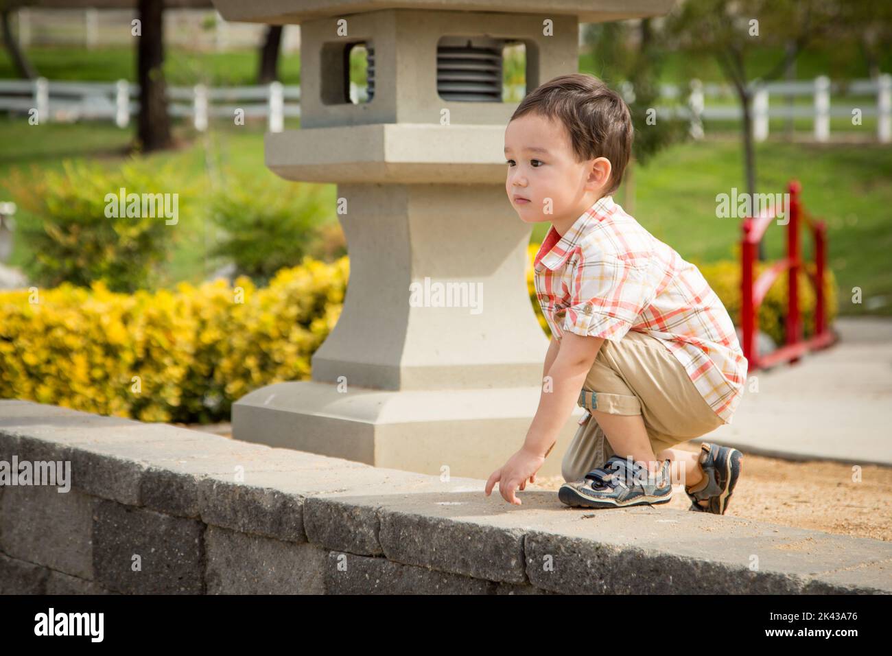 Un jeune garçon chinois et caucasien s'amuser au parc. Banque D'Images