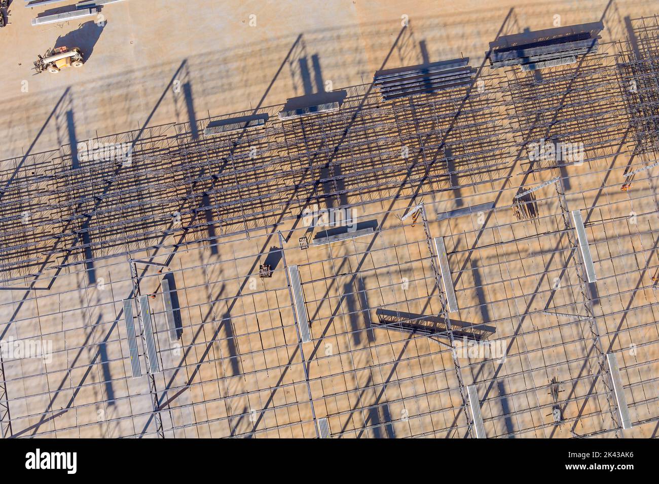 Installation d'un cadre de charpente de toit d'entrepôt en acier pendant la construction d'un bâtiment industriel Banque D'Images