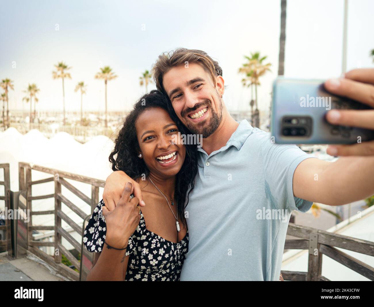 Un jeune couple multiethnique souriant prend un selfie lors de vacances tropicales. Banque D'Images