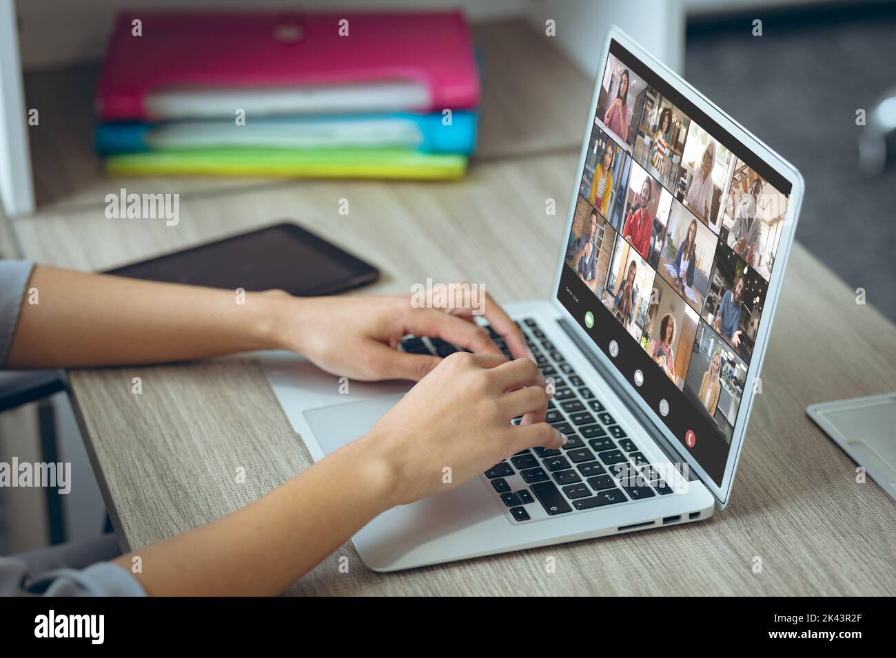 Rogner les mains d'une femme caucasienne en visioconférence avec ses collègues sur un ordinateur portable au bureau Banque D'Images