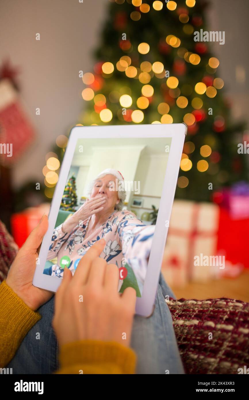 Redhead woman sitting on couch using tablet à Noël à la maison dans le salon Banque D'Images