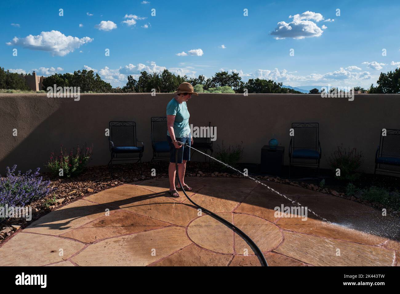Etats-Unis, Nouveau-Mexique, Santa Fe, femme lavant le patio le jour ensoleillé Banque D'Images