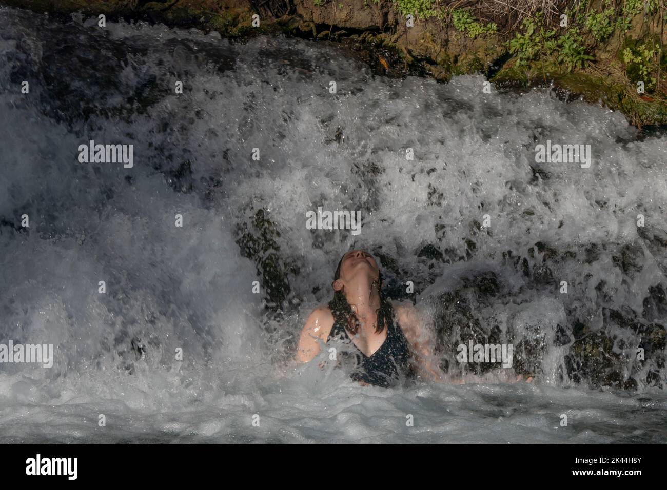 Une femme israélienne se baigne dans un bassin naturel d'eau de source du ruisseau Amal qui traverse le parc national de Gan Hashlosha également connu sous son nom arabe Sakhne en Israël Banque D'Images