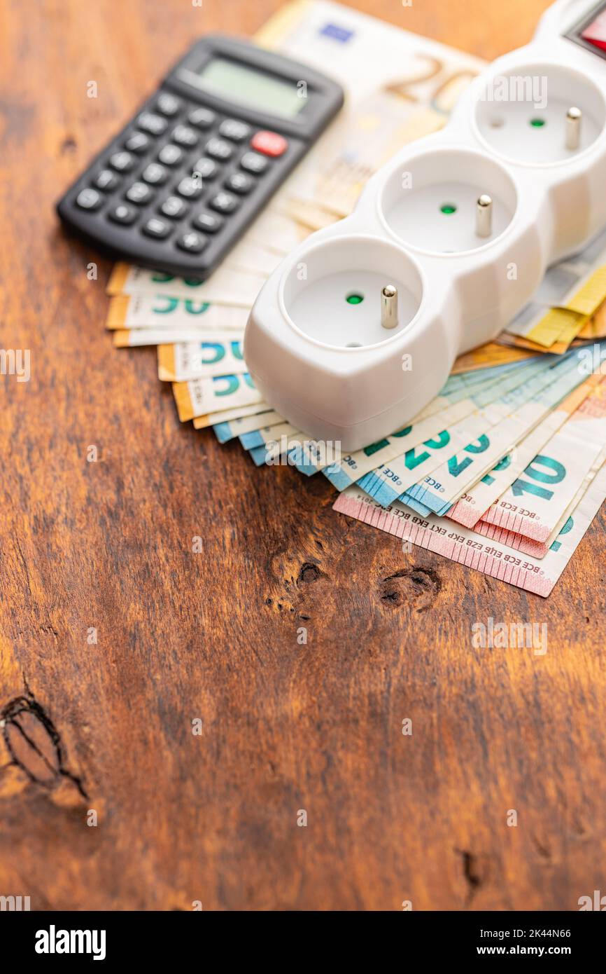 Prise électrique et euro argent sur la table en bois. Concept d'augmentation des prix de l'électricité. Banque D'Images