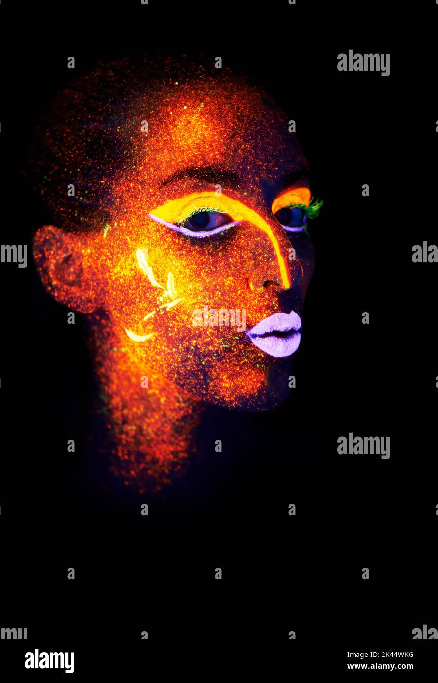 Baiser au néon. Une jeune femme avec de la peinture au néon sur son visage posant. Banque D'Images