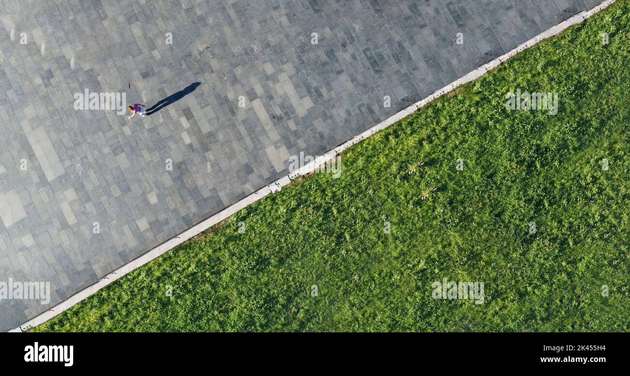 Tir de drone d'une jeune femme profitant d'une belle journée ensoleillée sur des patins à roulettes Banque D'Images