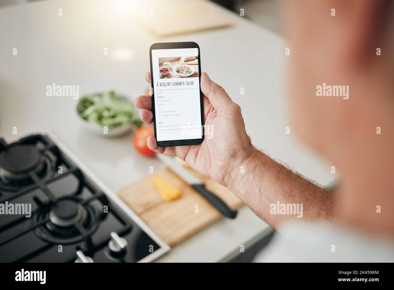 Écran de téléphone, recette de cuisine et homme avec des informations de salade de cuisine saine sur le site Web, blog numérique ou l'application de nourriture végétalienne. Main avec smartphone, Internet Banque D'Images
