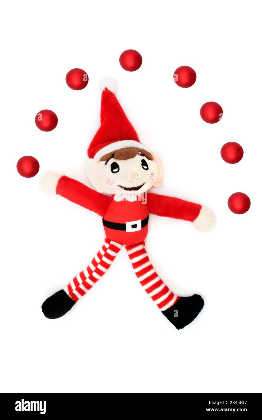 Décoration de Noël en forme de boule rouge juggling Elf, amusement festif avec l'aide du père noël sur fond blanc. Jouet rétro pour les fêtes. Banque D'Images