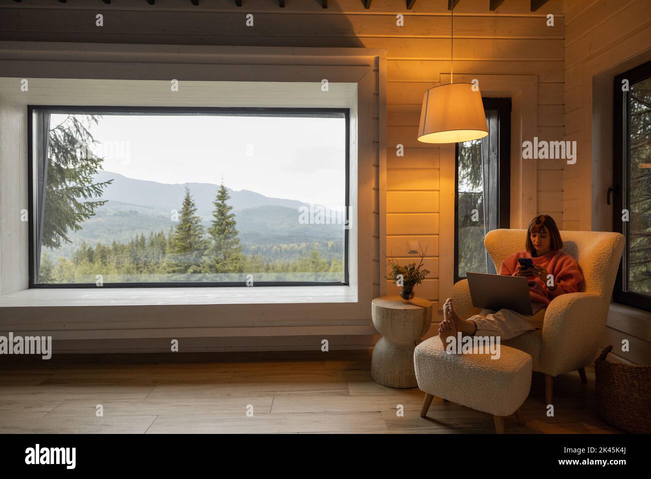 Femme travaille sur ordinateur portable à la maison dans les montagnes Banque D'Images