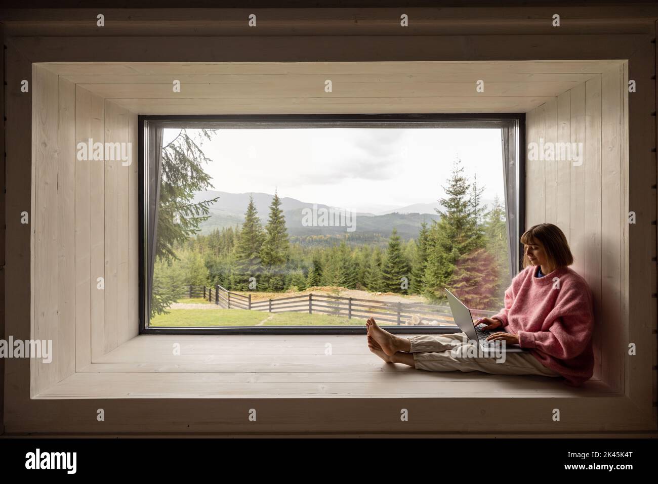 Femme travaille sur ordinateur portable à la maison dans les montagnes Banque D'Images