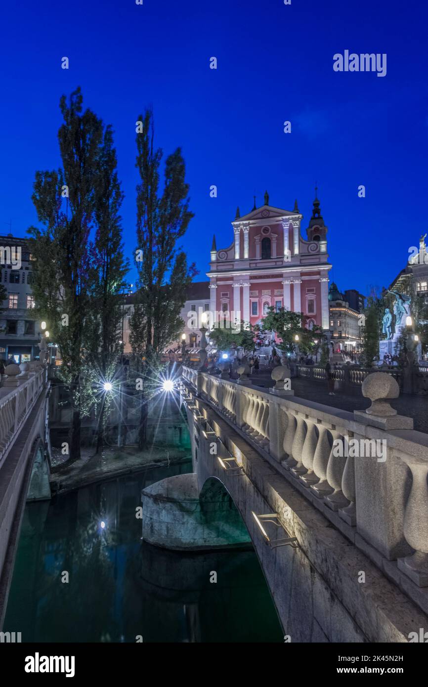 Château de Ljubljana la nuit, avec le triple pont en premier plan. Banque D'Images