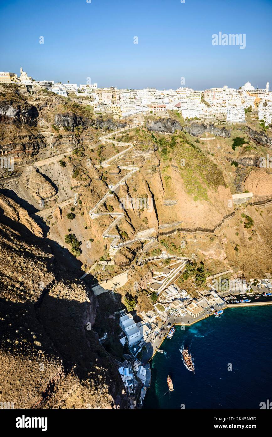 Vue aérienne d'une ville au sommet d'une falaise sur l'île d'Egeo et le chemin sinueux vers les maisons depuis le point d'atterrissage sur la côte. Banque D'Images