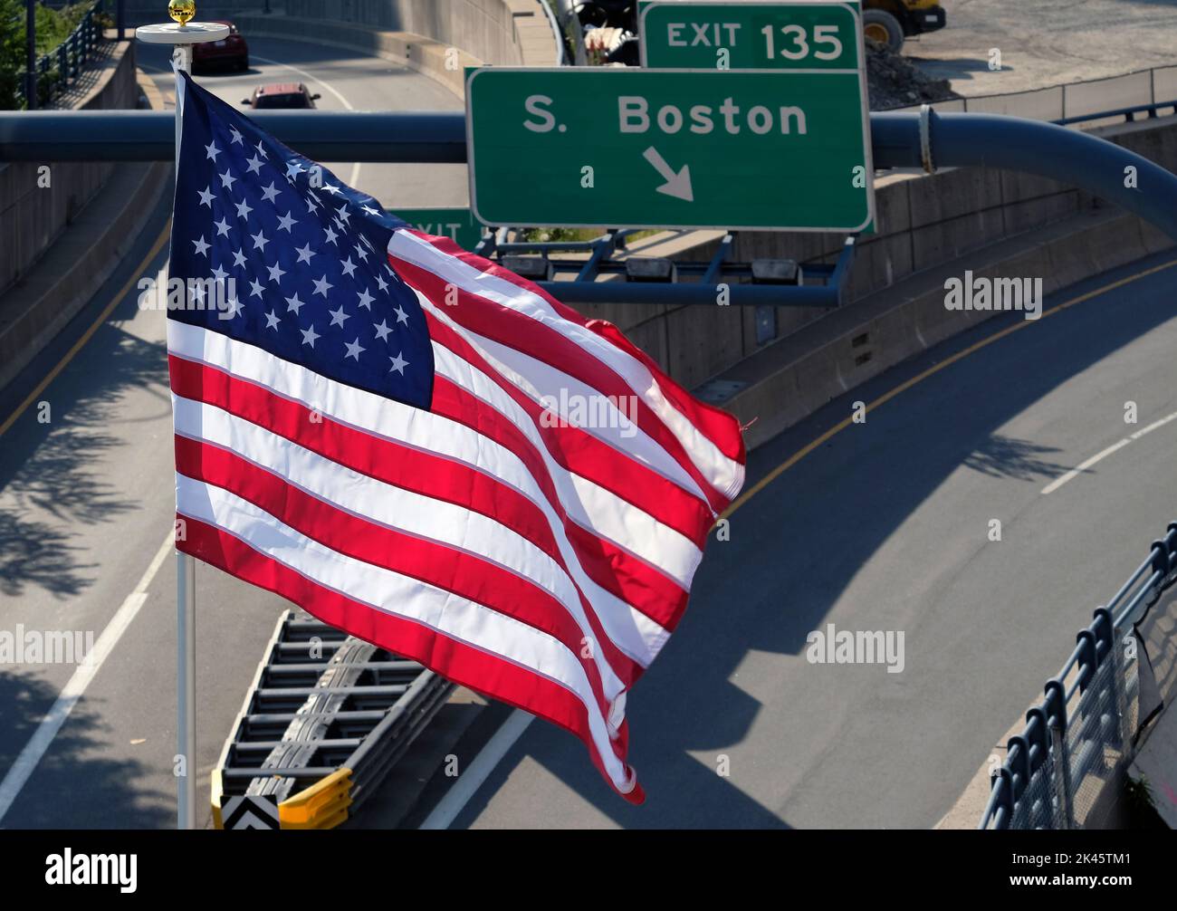 Drapeau américain à côté d'une sortie de l'autoroute vers Boston Banque D'Images