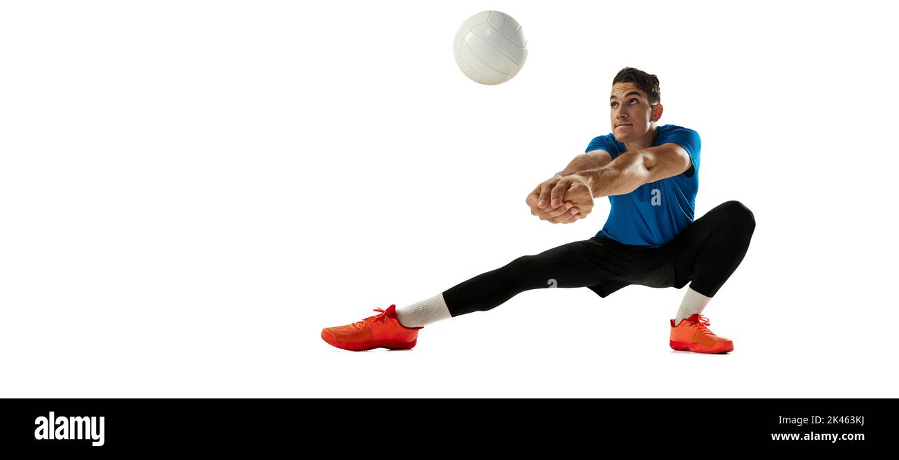 Studio tourné d'un jeune homme, joueur de volley jouant au volley-ball isolé sur fond blanc de studio. Sport, gym, sport d'équipe, défis Banque D'Images