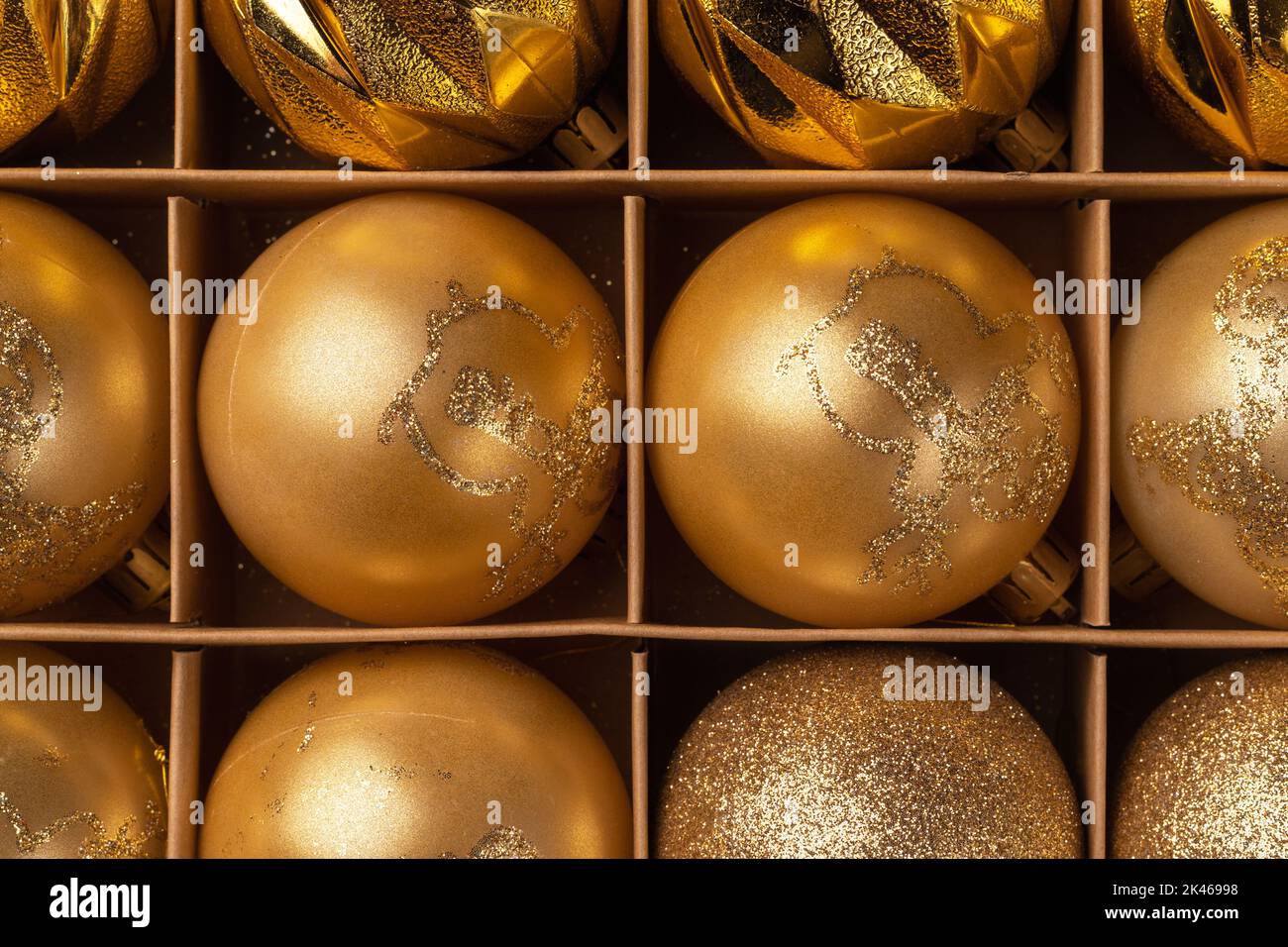 Boules de Noël dorées scintillantes dans une boîte en carton. Vue de dessus Banque D'Images
