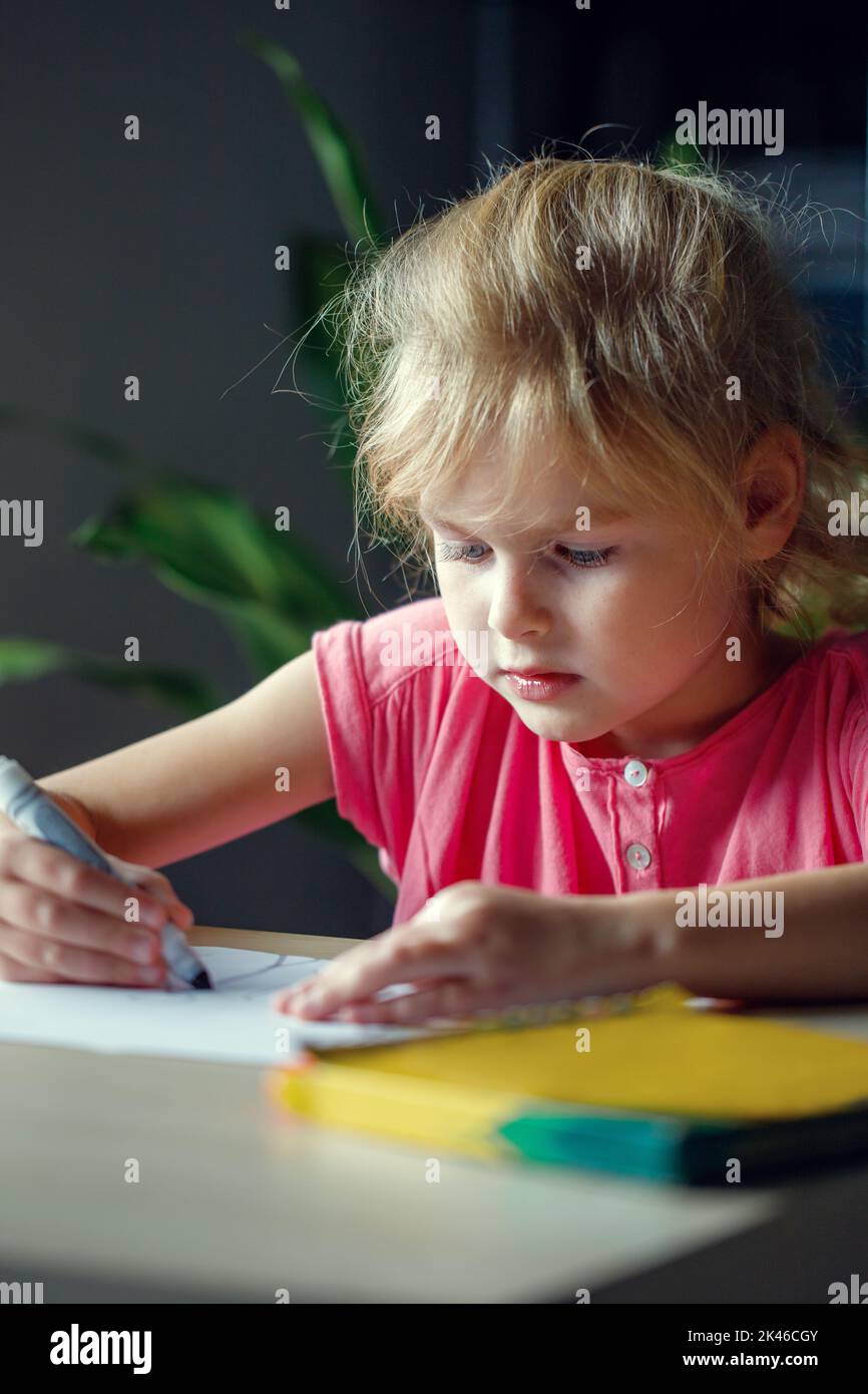 Dessin enfant avec marqueurs de couleur. Petite fille, assise à la table. Banque D'Images