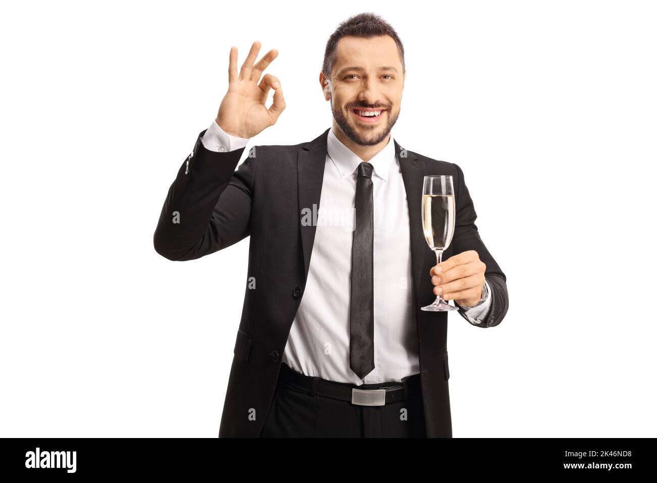Homme d'affaires tenant un verre de champagne et gesturant bon signe isolé sur fond blanc Banque D'Images