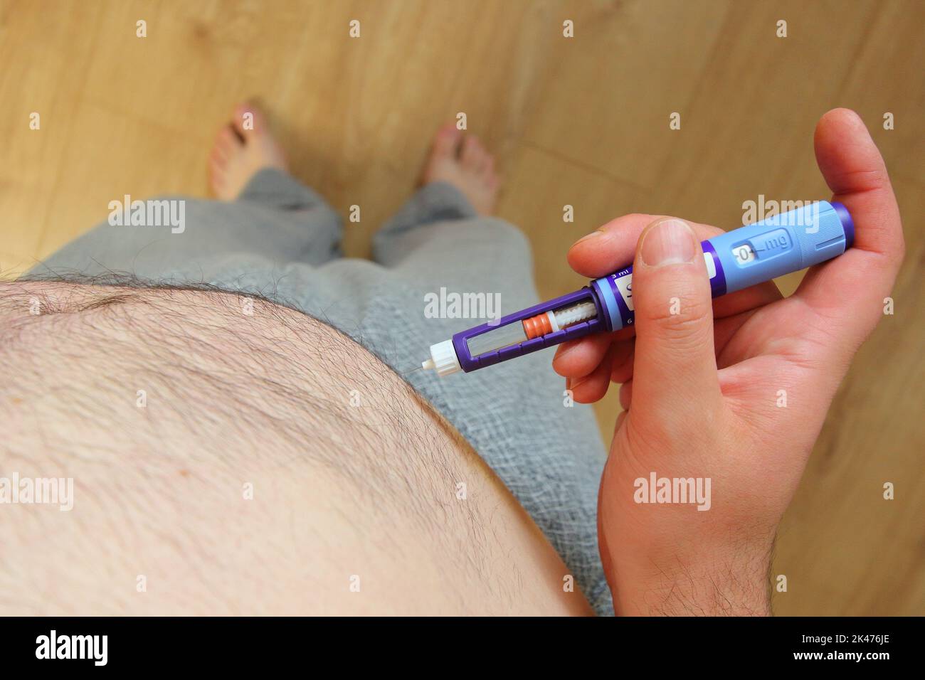 Homme en surpoids appliquant une injection de médicaments contre le diabète (seringue) dans son estomac, son ventre Banque D'Images