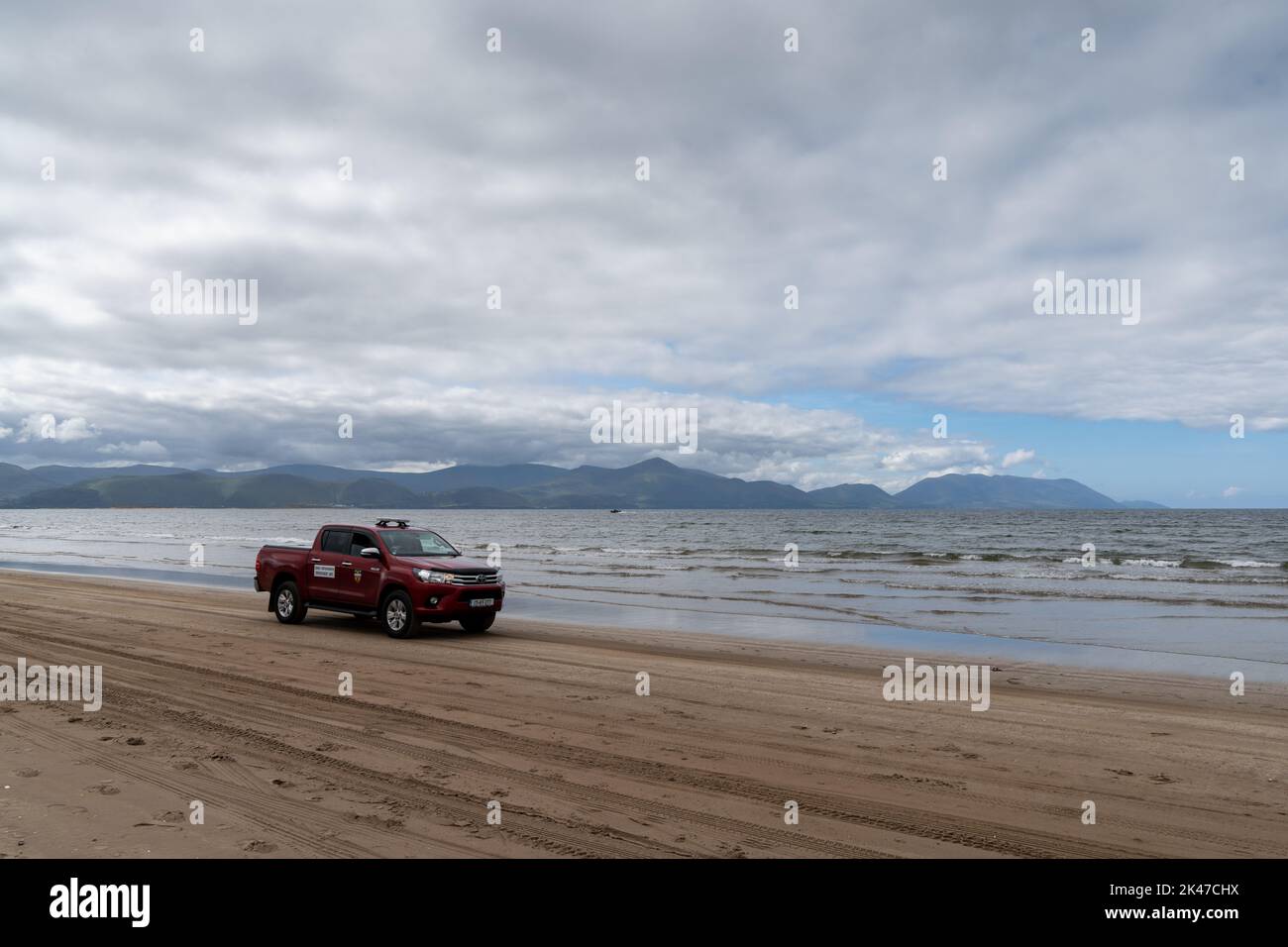 Inch Strand, Irlande - 5 août 2022 : camion de sauvetage rouge roulant sur la plage de Inch Strand en Irlande occidentale Banque D'Images