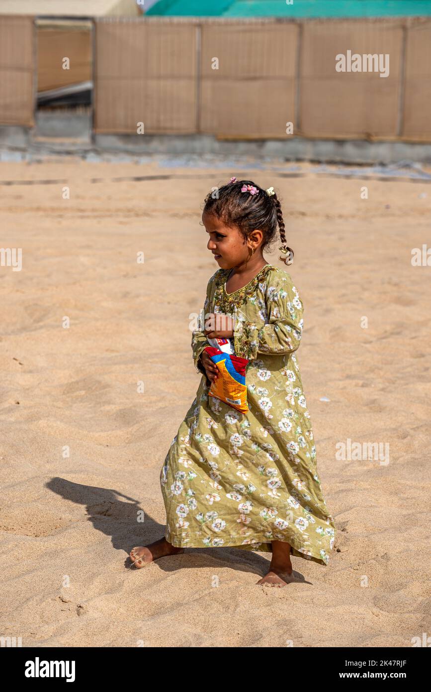 Une jeune fille pieds nus dans un camp bédouin, dans le sud de l'Oman Banque D'Images