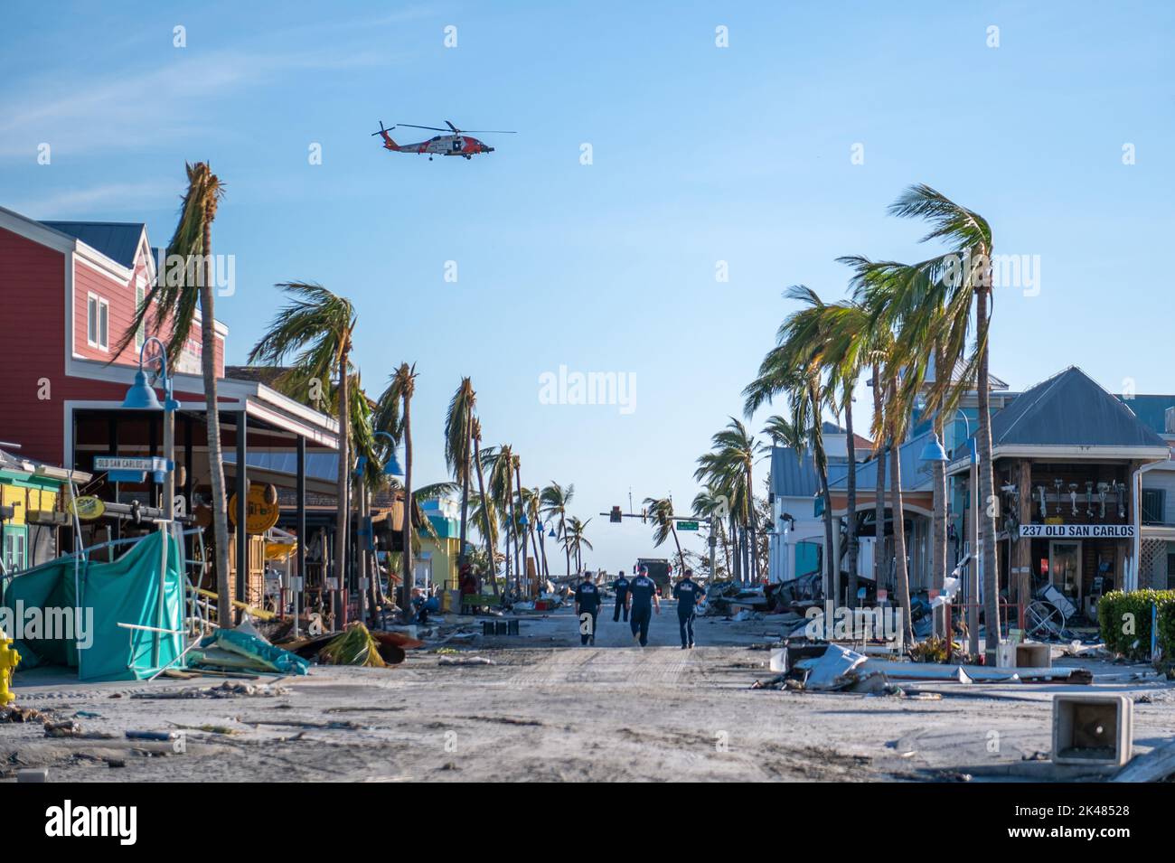 À la suite de l'ouragan Ian, un hélicoptère Jayhawk de la Garde côtière vole au-dessus de la tête, tandis que les équipes de la Force nationale de grève de la Garde côtière effectuent des recherches et des opérations de sauvetage en milieu urbain pour des personnes disparues à fort Myers Beach, en Floride, sur 29 septembre 2022. (ÉTATS-UNIS) Banque D'Images