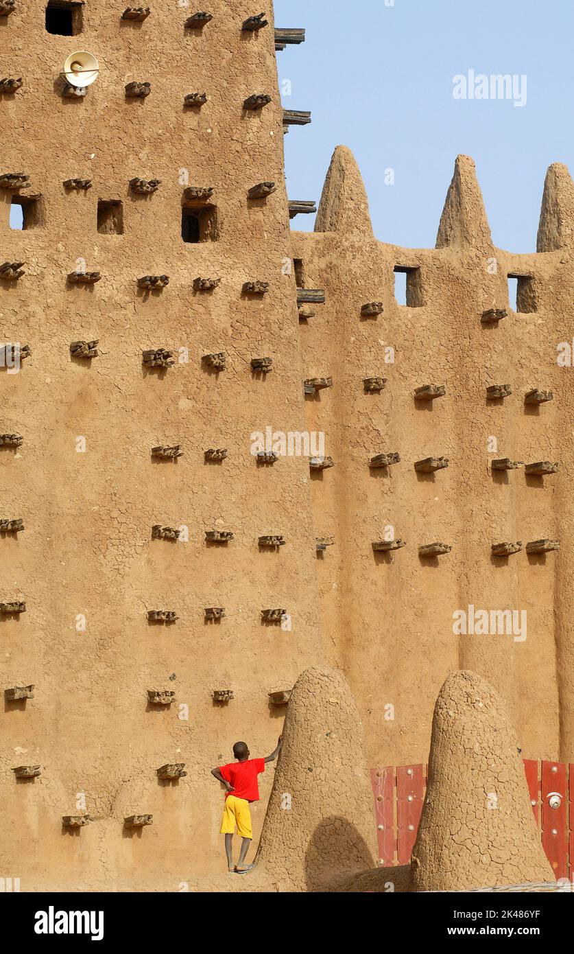 Mali. Djenne. Enfant sur les murs de la mosquée de Djenne. Construit en 1909, c'est le plus grand bâtiment au monde jamais fait avec de l'argile (demeure). Banque D'Images