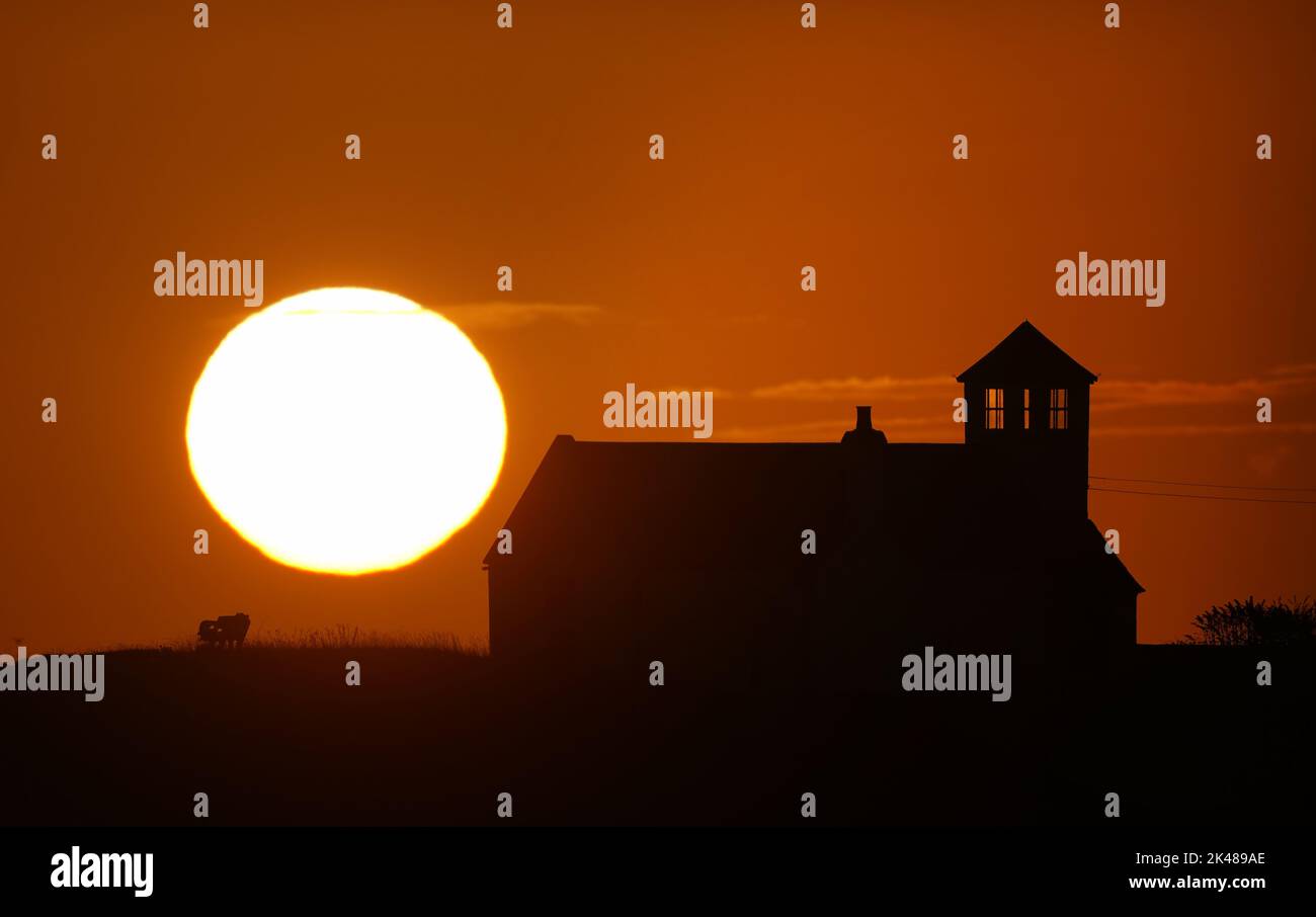 Le soleil se lève au-dessus de Watch House sur Rocky Island à Seaton Sluice, Northumberland. Date de la photo: Samedi 1 octobre 2022. Banque D'Images