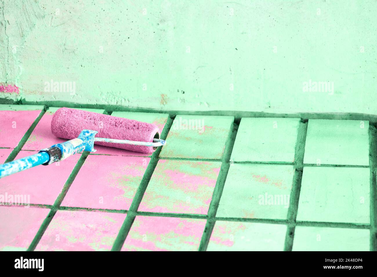 Rouleau peinture de la surface murale verte avec de la peinture rose Banque D'Images Rouleau peinture de la surface murale verte avec de la peinture rose Banque D'Images