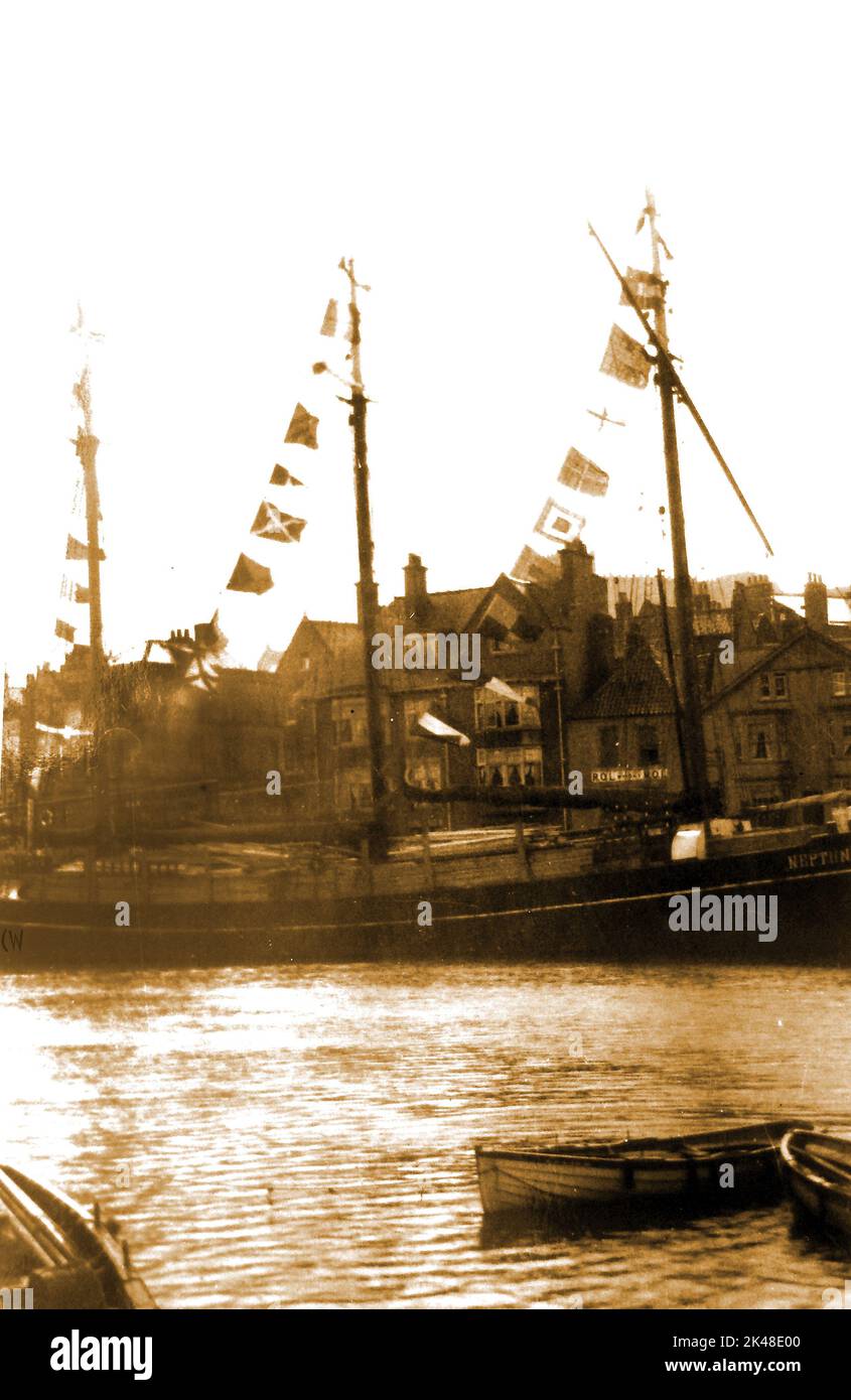 Une photo très ancienne d'un navire à trois mâts amarré juste au-dessus du pont à Whitby, dans le North Yorkshire, au Royaume-Uni, avec des drapeaux. Derrière elle se trouve un panneau mural pour Rol Whisky (ou Whiskey) sur les caves à vin de Falkingbridge (maintenant démolies) Banque D'Images