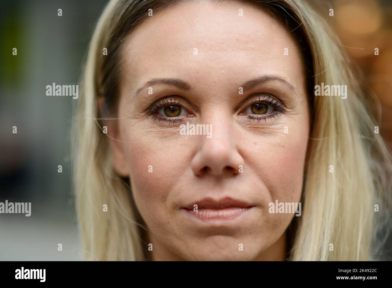 Gros plan d'une jolie femme blonde d'âge moyen avec une expression calme et détendue sur son visage Banque D'Images