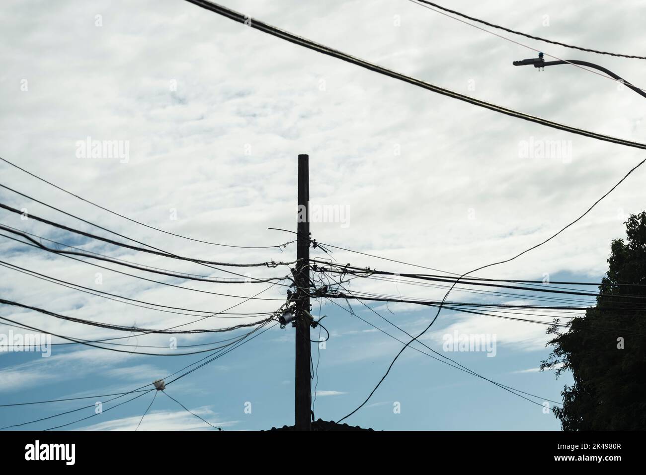 Poteau de service avec fils électriques contre ciel bleu nuageux. Salvador, Bahia, Brésil. Banque D'Images
