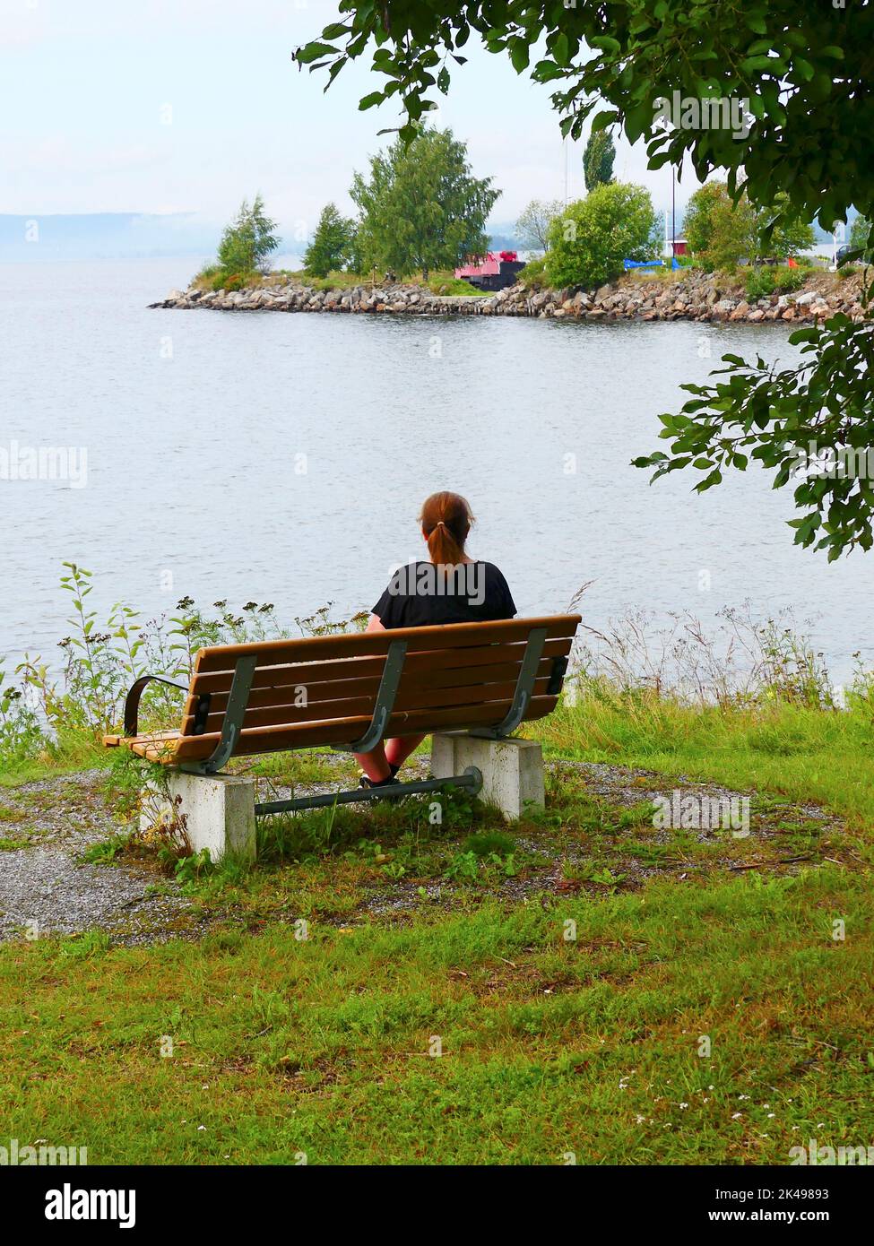 Femme sur un banc en bois Banque D'Images