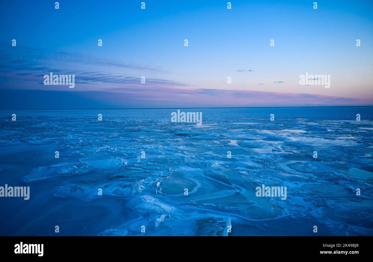 Vue aérienne du coucher de soleil sur la mer gelée. Paysage hivernal sur la mer au crépuscule. Vue depuis le dessus de la fonte de glace dans l'océan au lever du soleil avec horizon Banque D'Images