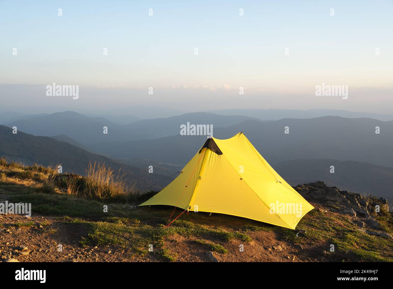 Tente jaune sur fond d'un paysage de montagne incroyable pendant le lever du matin. Des montagnes incroyables. Concept du tourisme Banque D'Images