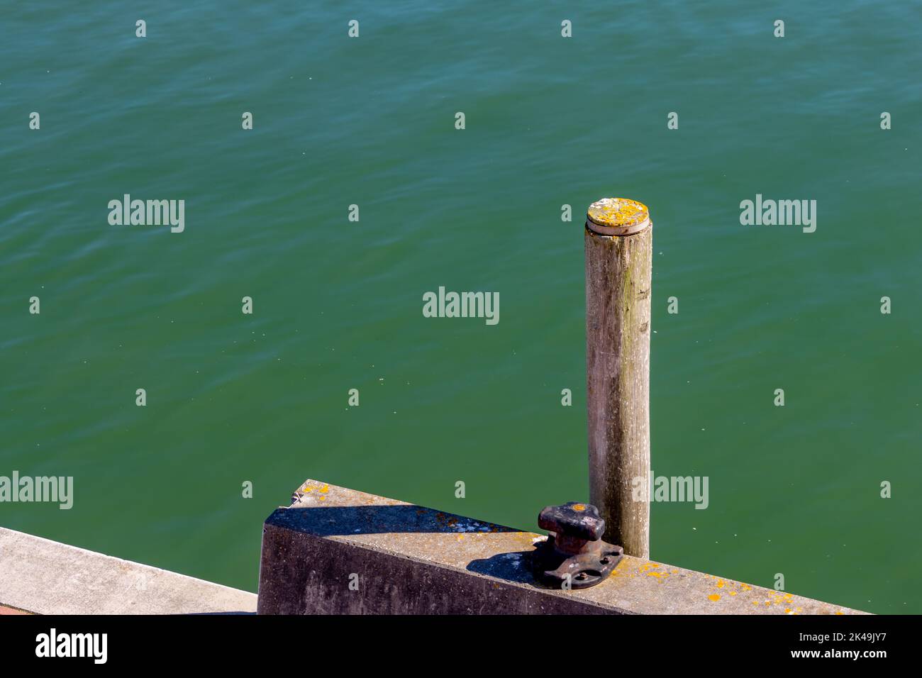 Pilier en bois ou poste d'amarrage le long d'un quai dans un port Banque D'Images