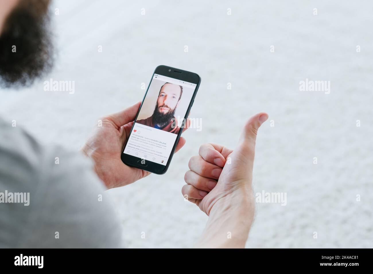 Application mobile. Profil utilisateur réseau. Médias sociaux. Commentaires positifs en ligne. Homme de soutien avec un smartphone montrant comme au visage image post pouce vers le haut ge Banque D'Images