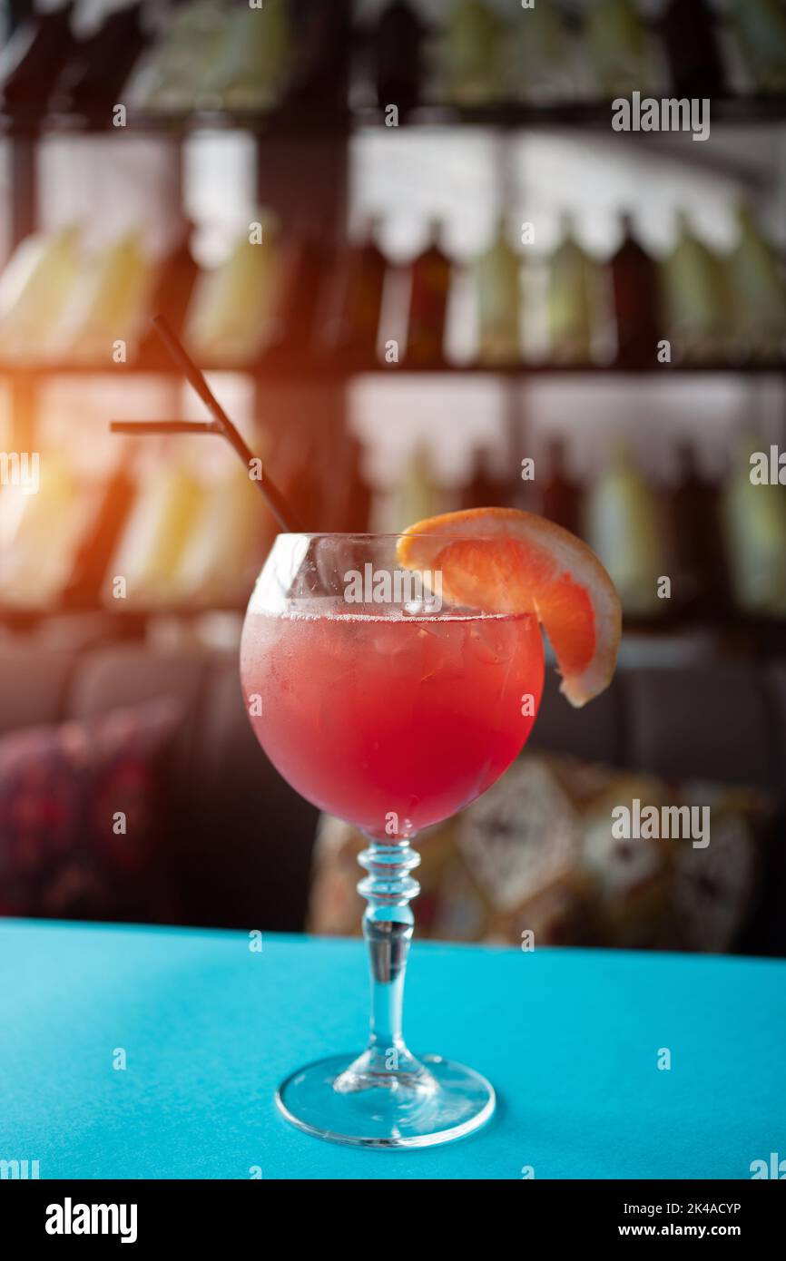 cocktail de pamplemousse rouge juteux avec paille au bar, au café ou au restaurant sur table Banque D'Images