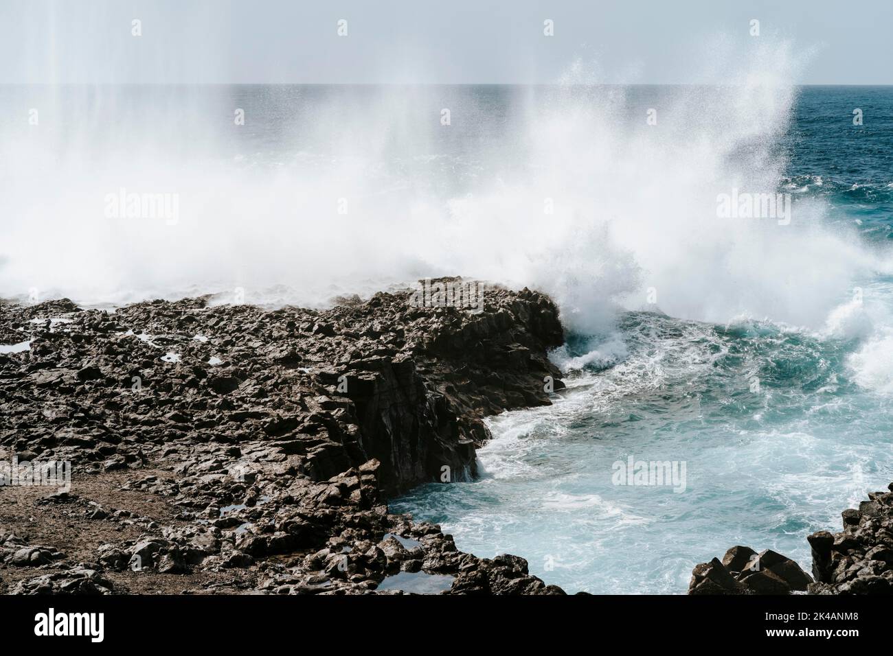 Éclaboussures d'eau sur les roches volcaniques noires de Tenesar, Lanzarote, îles Canaries, Espagne Banque D'Images
