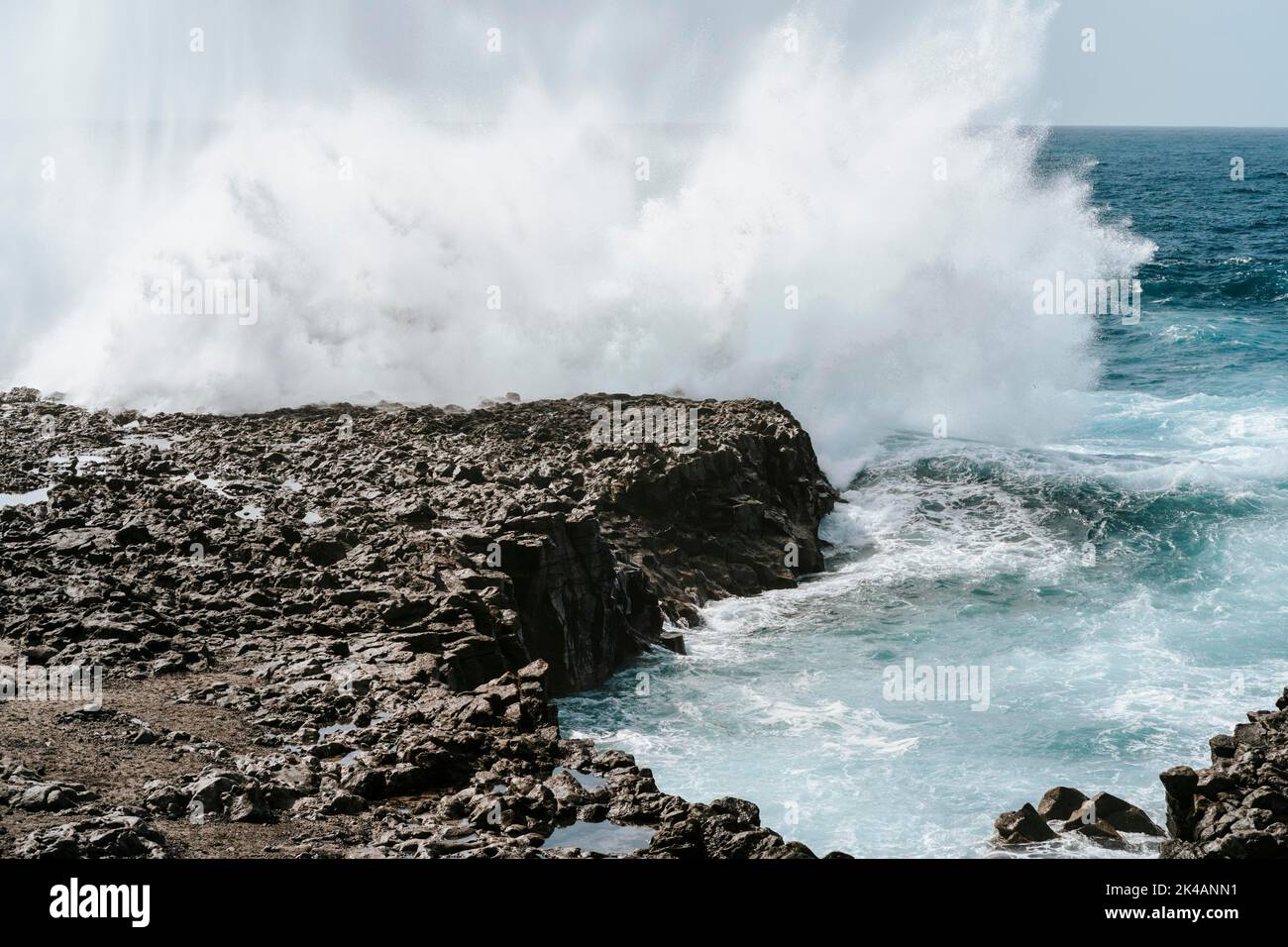 Éclaboussures d'eau sur les roches volcaniques noires de Tenesar, Lanzarote, îles Canaries, Espagne Banque D'Images