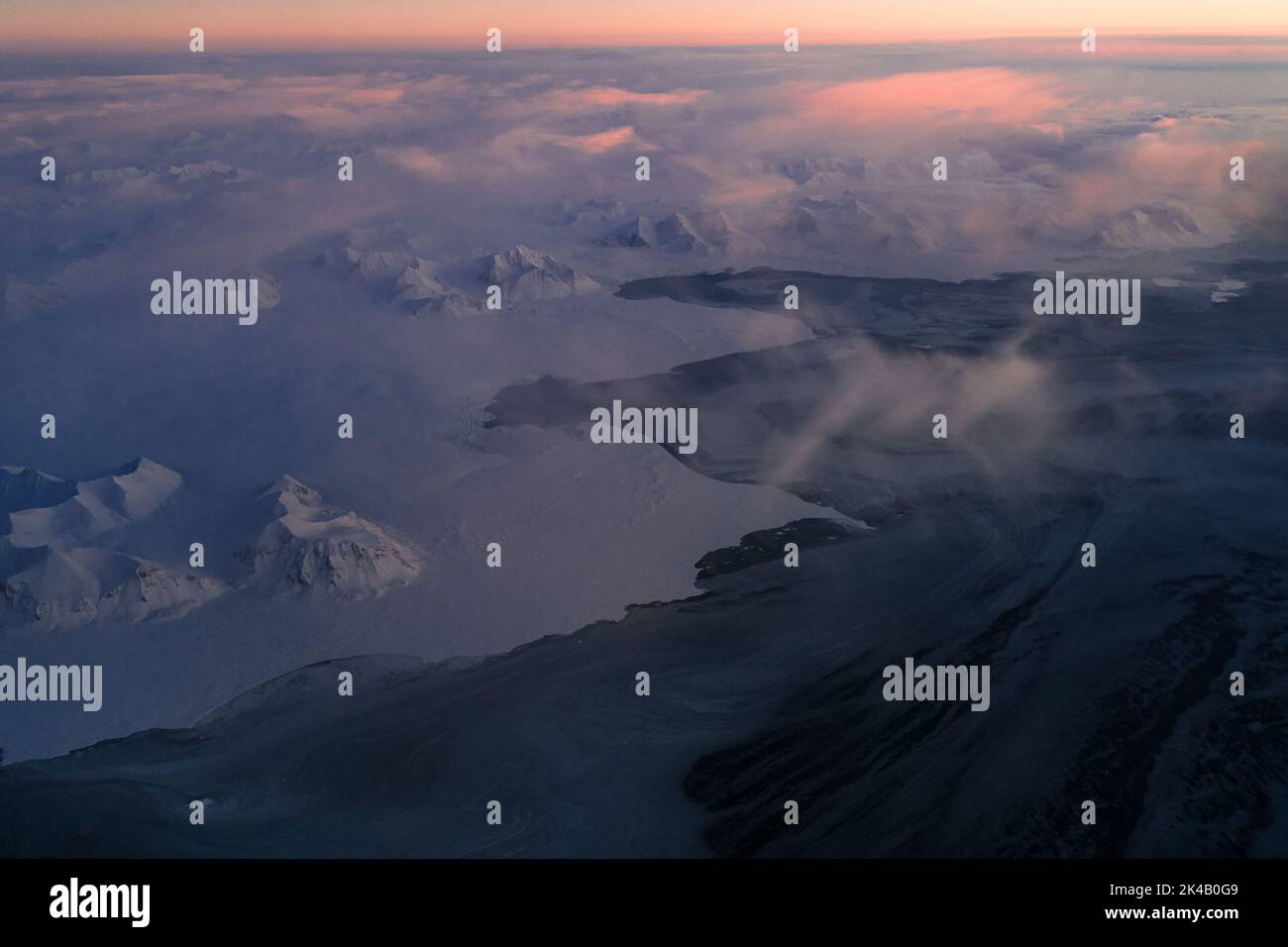 Photos aériennes uniques du paysage hivernal gelé et enneigé des montagnes et de la côte du Svalbard, prises depuis un avion / drone au coucher du soleil Banque D'Images