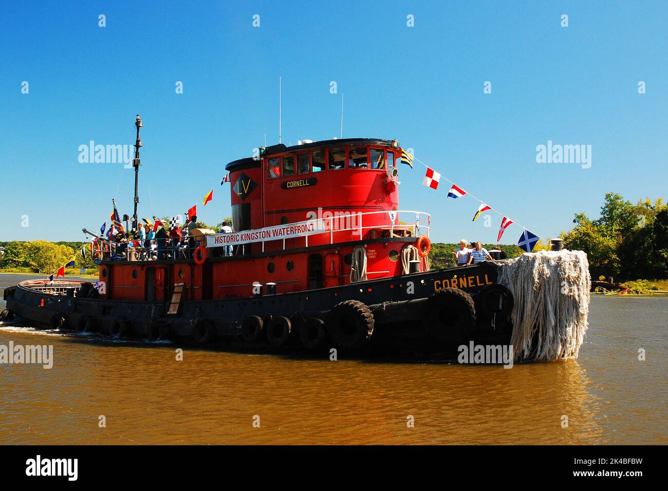 Le remorqueur rouge Cornell longe la rivière pour guider le prochain grand navire Banque D'Images