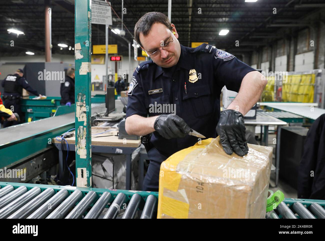 Agents le U.S. Customs and Border Protection, Bureau des opérations de terrain, l'écran des paquets pour contrefaçon de produits expédiés dans la région puisqu'ils participent à des opérations de sécurité précédant le Super Bowl IIL à Minneapolis, au Minnesota, le 29 janvier 2018. U.S. Customs and Border Protection photo par Glenn Fawcett Banque D'Images