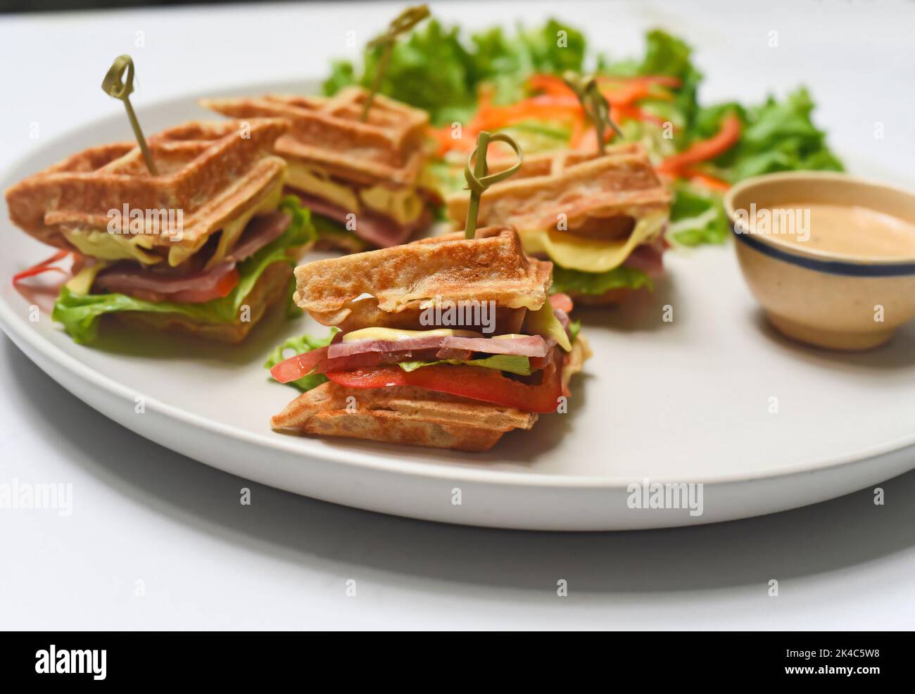 Gaufres belges sur une assiette blanche avec greens en gros plan Banque D'Images