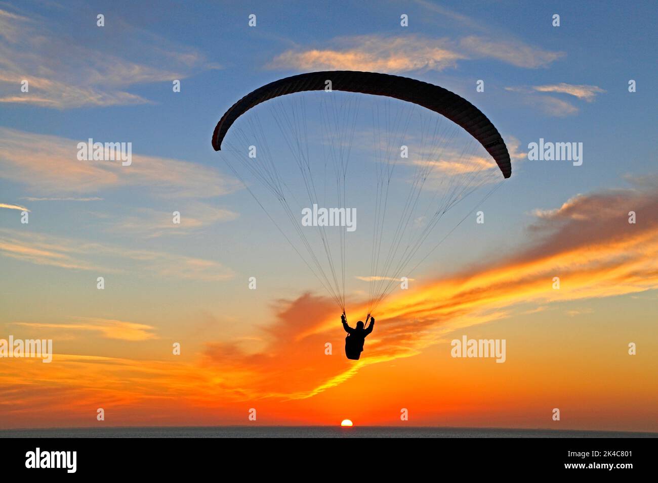 Hang Glider, parachute, contre le coucher du soleil, le ciel, Norfolk, Angleterre, Royaume-Uni Banque D'Images