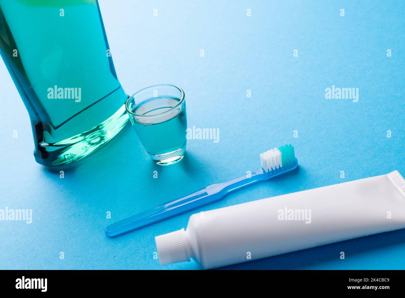 Image du liquide de nettoyage, de la brosse à dents et du dentifrice sur une surface bleue Banque D'Images