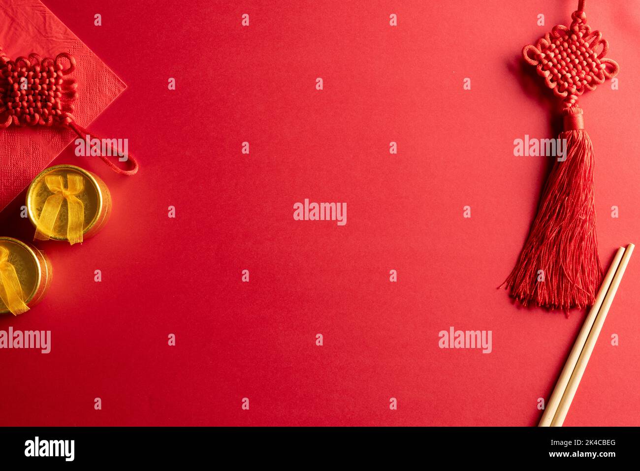 Composition de décorations et baguettes chinoises traditionnelles sur fond rouge Banque D'Images