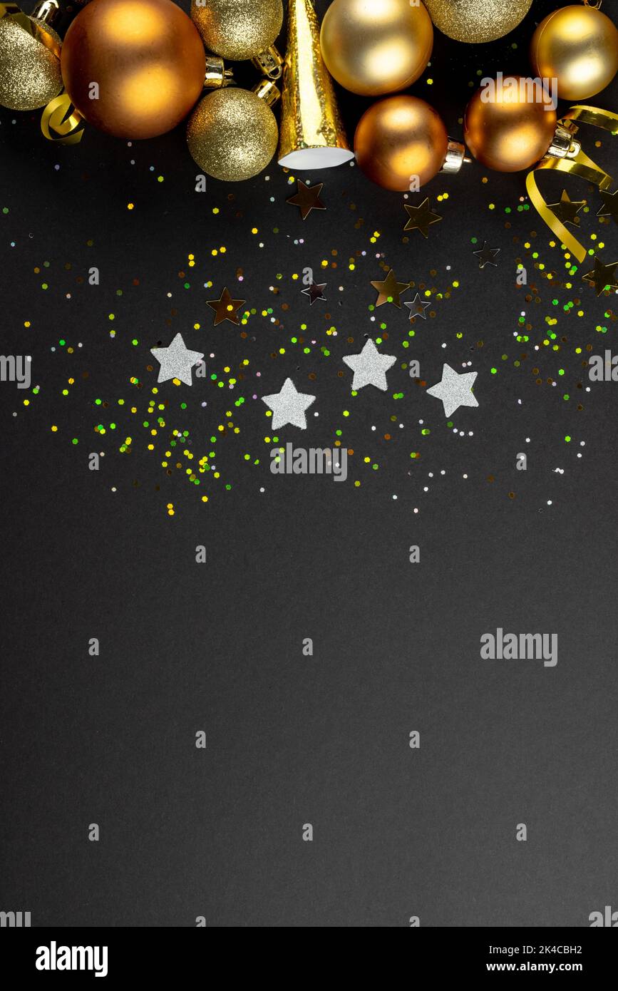 Composition de gros plan de décorations du nouvel an et confetti sur fond noir Banque D'Images