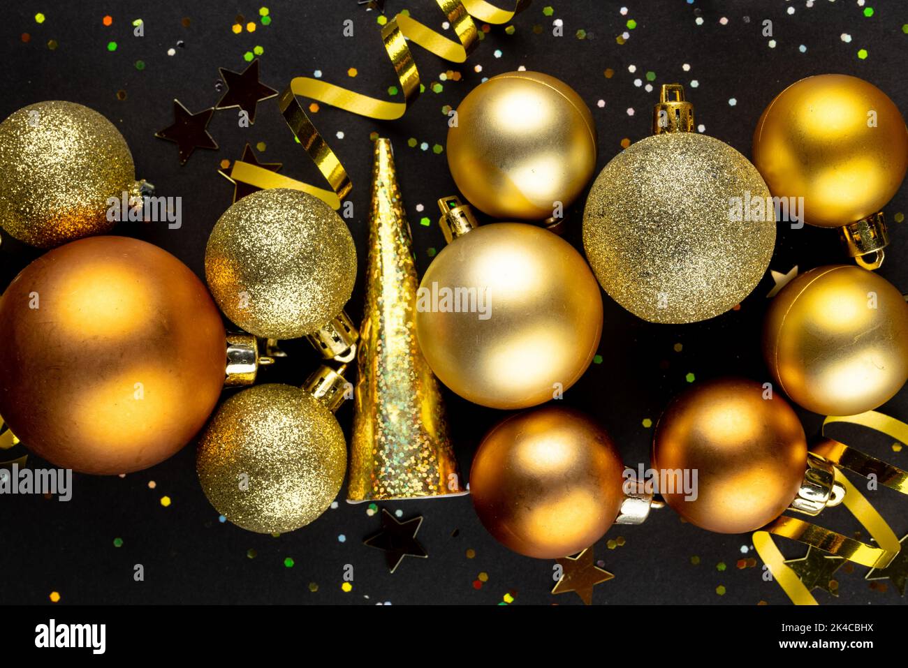 Composition de gros plan de décorations du nouvel an et confetti sur fond noir Banque D'Images